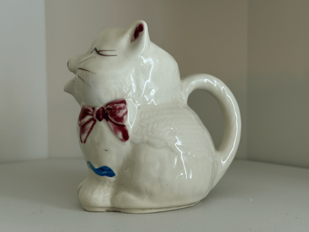 Shawnee ceramic cat pitcher with a burgundy bow tie and blue decoration.